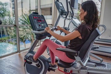 indonesian woman using recumbent exercise bike in a gym