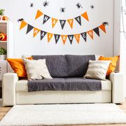 living room decorated for halloween with banner and spiderweb