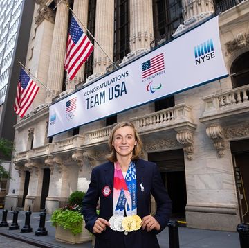a person holding a trophy in front of a building with flags