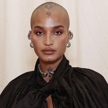 indya moore poses for a photo, wearing a large black cape with sleeves, at the 2021 met gala, september 2021