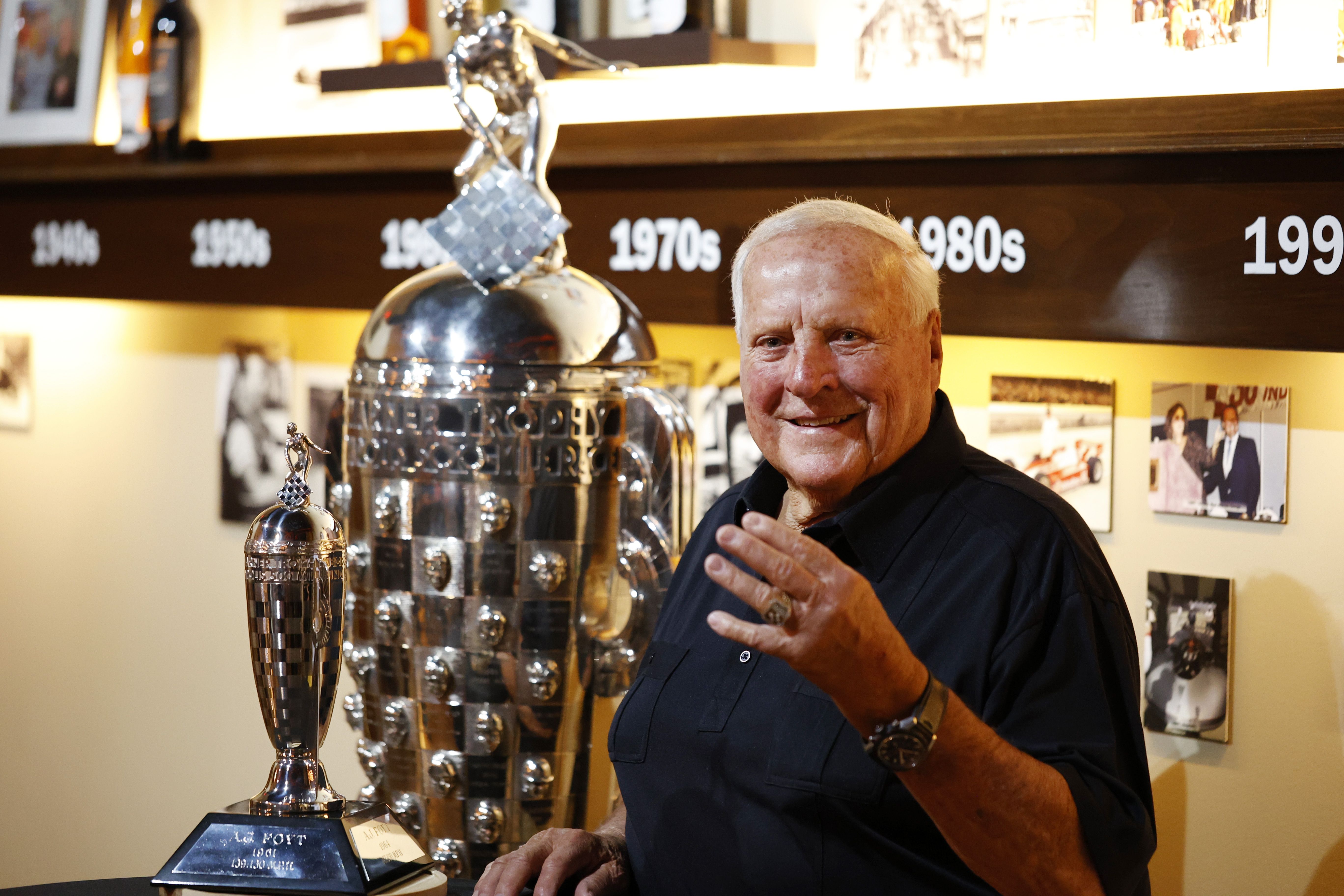 An older AJ Foyt proudly holding a record plaque, representing AJ Foyt's Untold Speed Records and enduring legacy