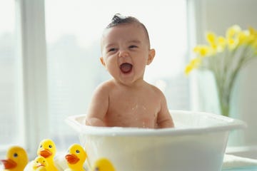 bebé en bañera con patos de goma
