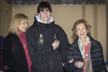a group of three people standing together indoors