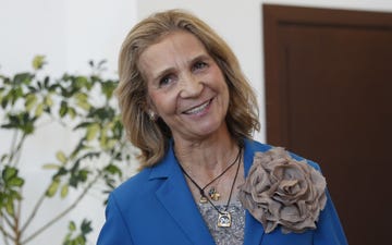 la hermana de felipe vi sonrie con el pelo lizo, una blazer azul con una gran flor en la solapa