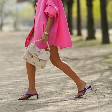 paris, france   april 01 xenia adonts wears a neon pink long oversized shirt  dress from valentino, a white valentino studded bag, a golden watch, a golden bracelet, purple valentino shoes  sandals, during a street style fashion photo session, on april 01, 2021 in paris, france photo by edward berthelotgetty images