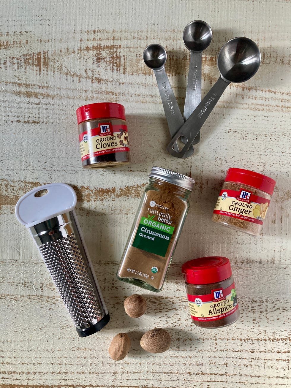 ingredients for pumpkin pie spice on a white painted wood surface