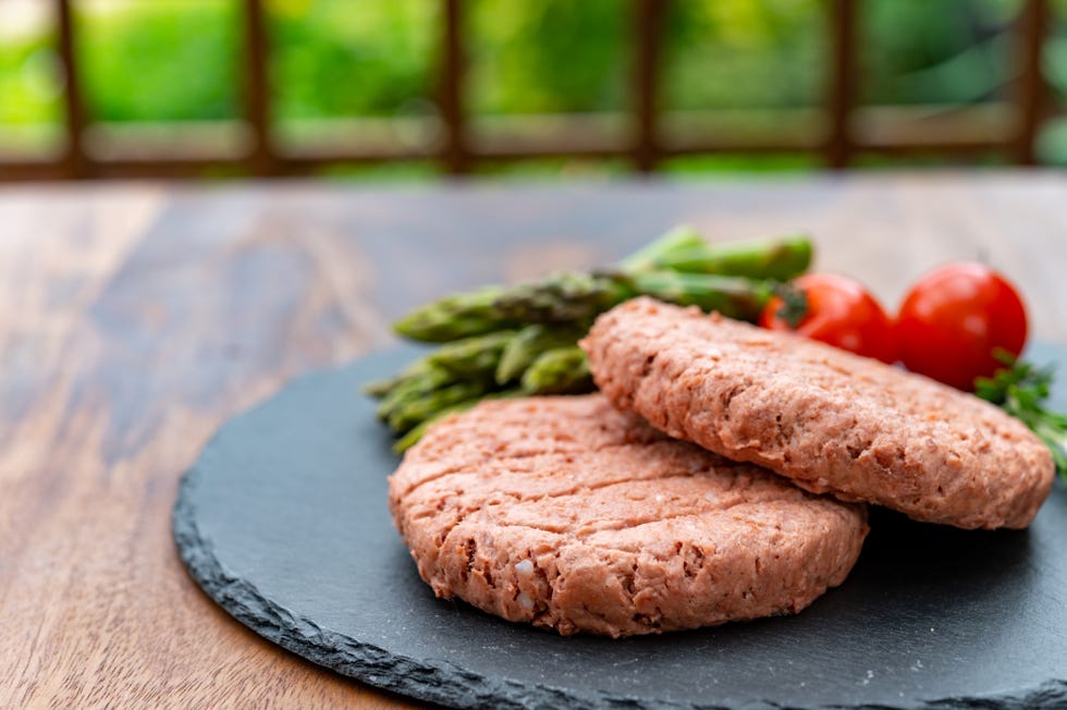 ingredients for tasty vegan dinner, meat free plants based steak, green asparagus and red tomatoes