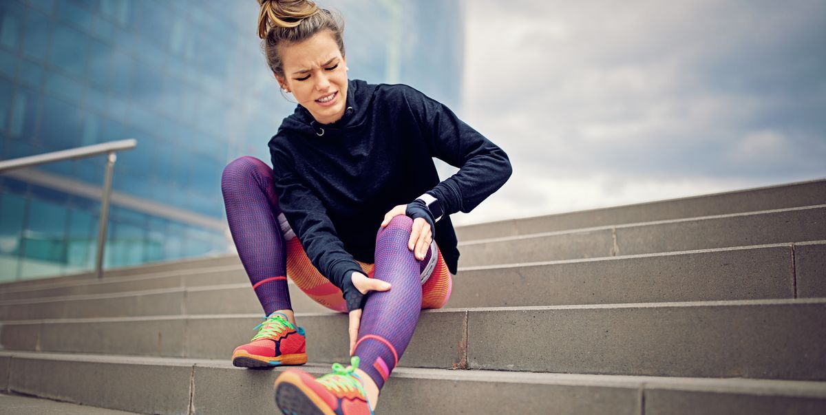 injured runner girl is sitting on the city stairs