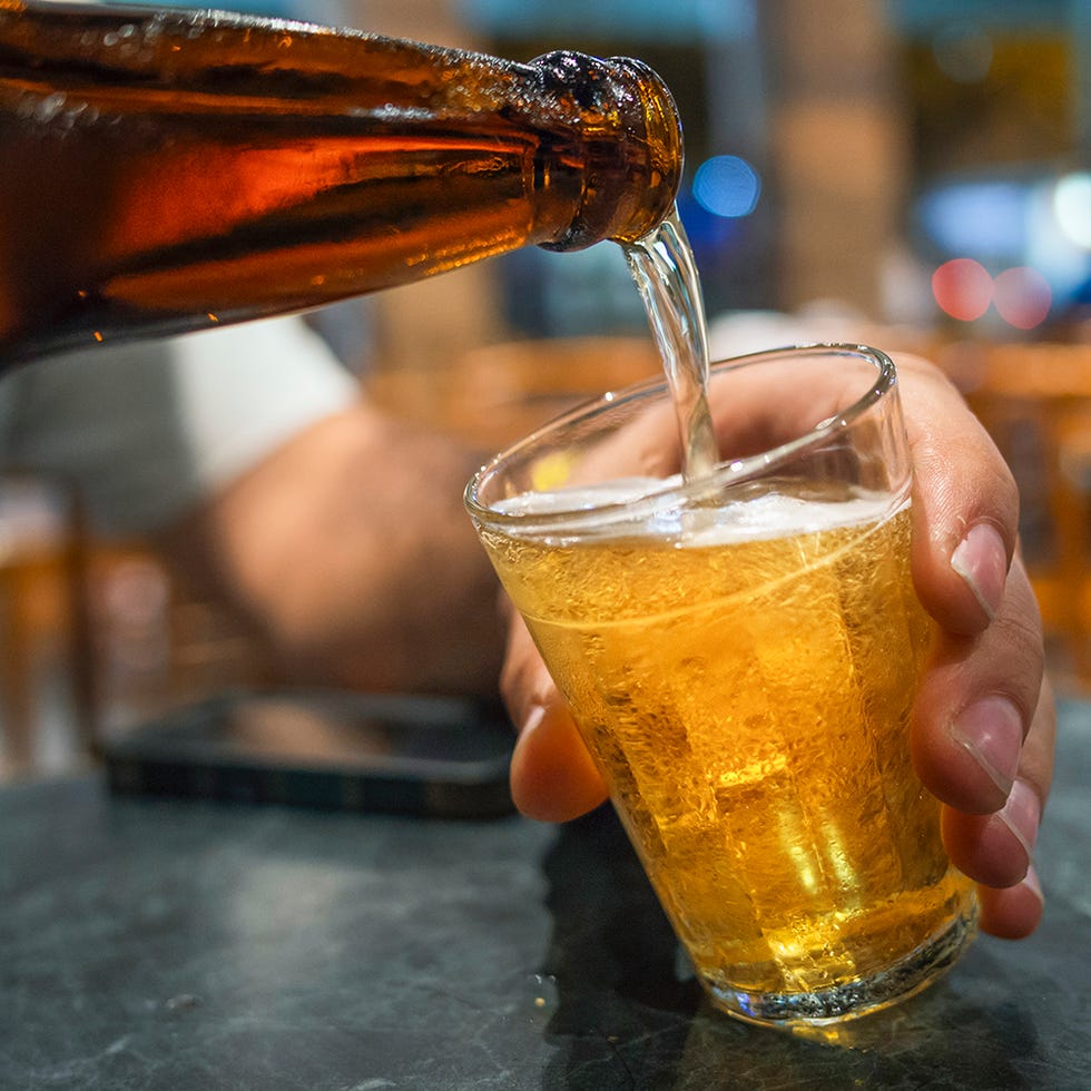 a man pours beer into a glass in a brazilian bar