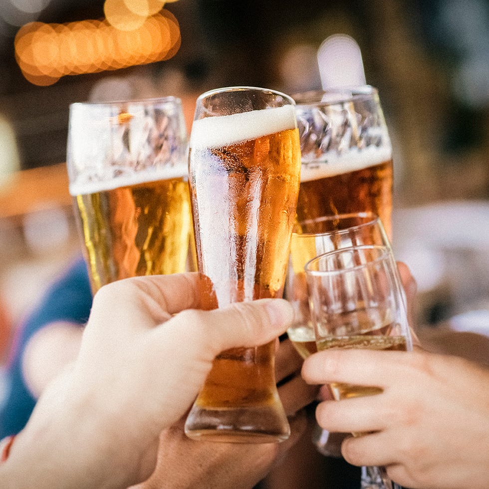 friends raising celebratory toast during party hands of man and woman are holding drinks they are enjoying at restaurant