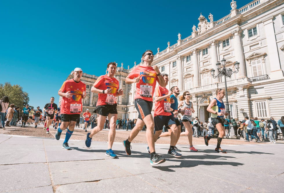 varios corredores pasan por delante del palacio real durante el maratón de madrid 2019