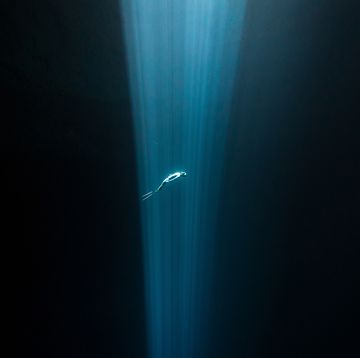 freediver in a beam of light