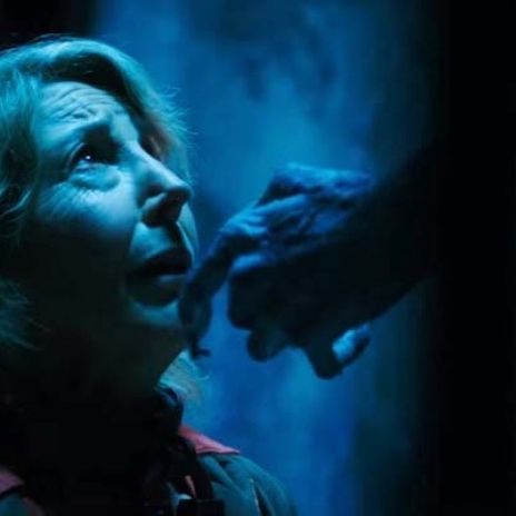 a demon with keys for fingers touches elise's face in a scene from insidious the last key