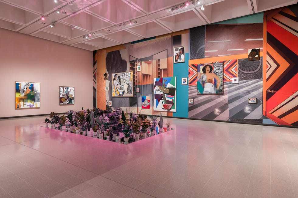 art gallery featuring a vibrant wall installation with various artworks and a plant display