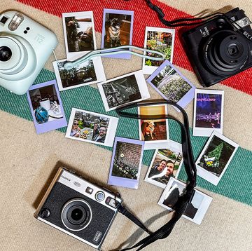 three instant cameras with a variety of polaroids
