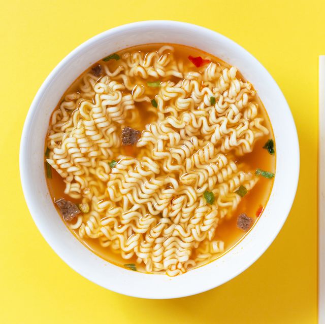 instant noodle soup in a white bowl on yellow background top view