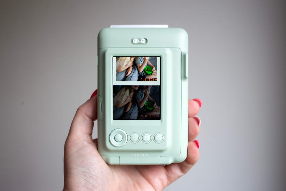 compact photo printer held in hand displaying two images