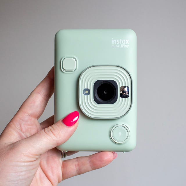compact instant camera held in hand featuring a minimalist design