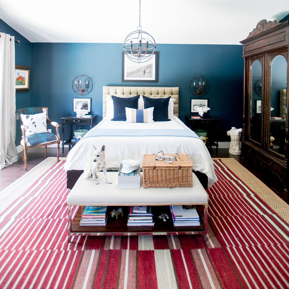 bedroom with blue walls and red and white striped rug
