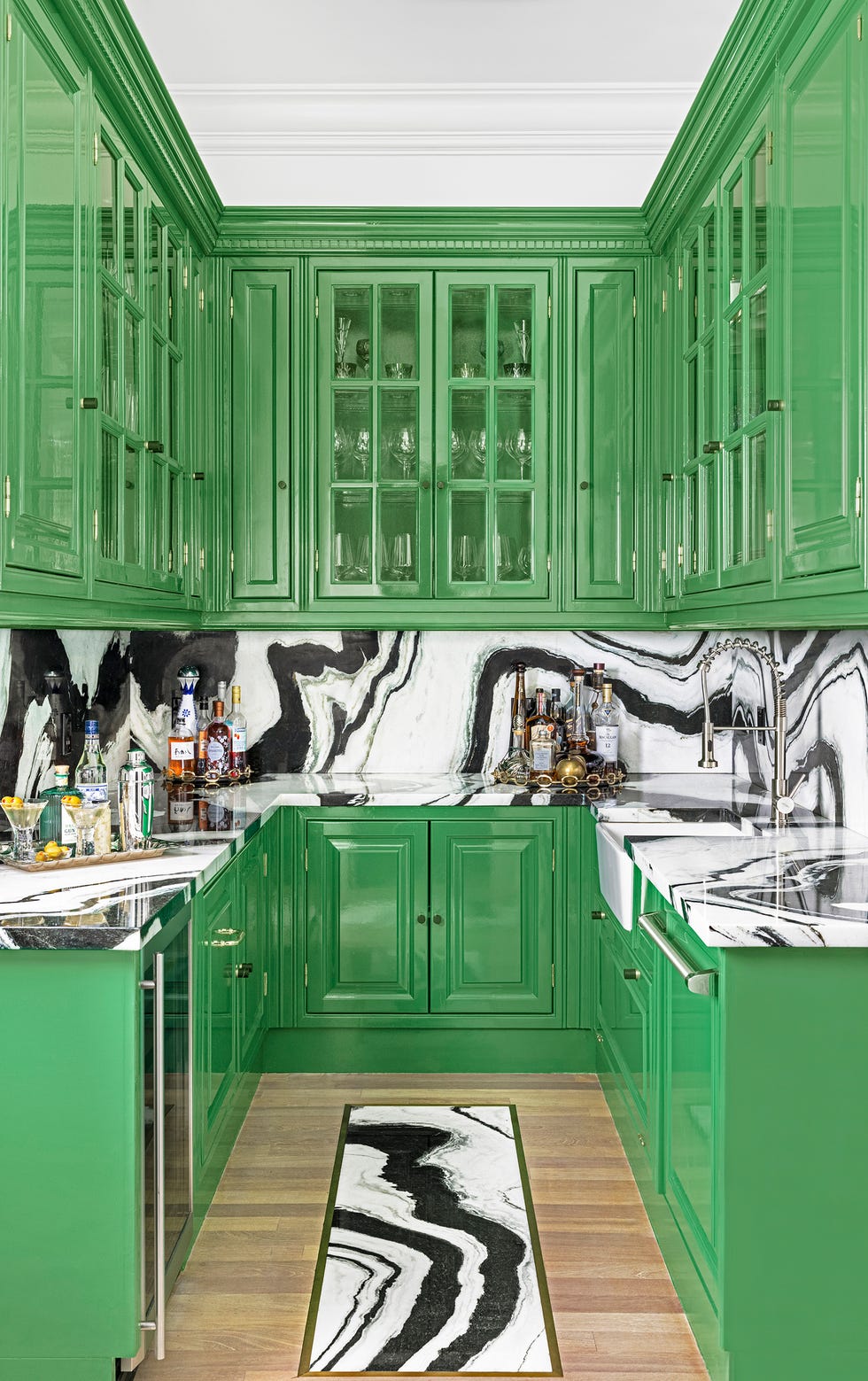 glossy green kitchen with artistic tile marble backsplash and countertop