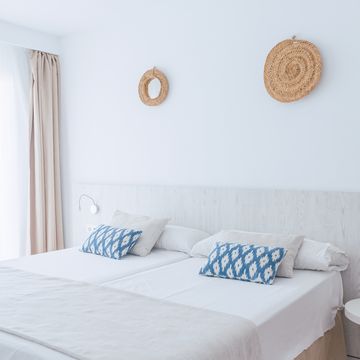 interior of a tidy mediterranean hotel room with natural sunlight coming in through the window