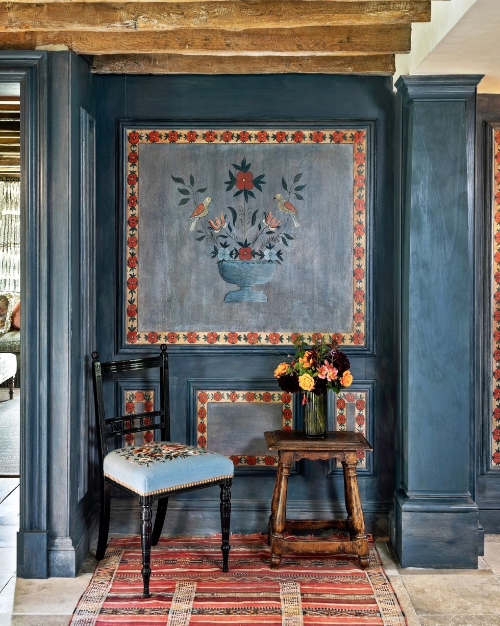 a blue painted hallway with folk style painted panels
