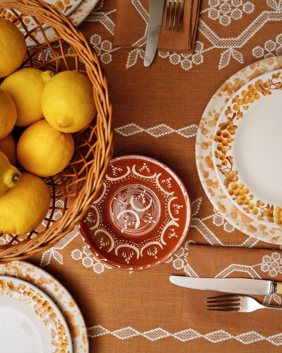 an orange and yellow tablescape with splatterware plates
