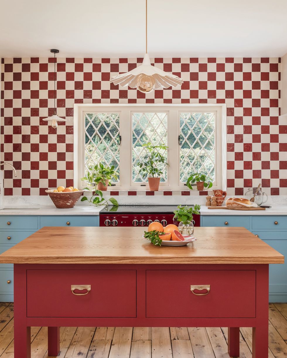 a kitchen with red and white checkerboard wall tiles