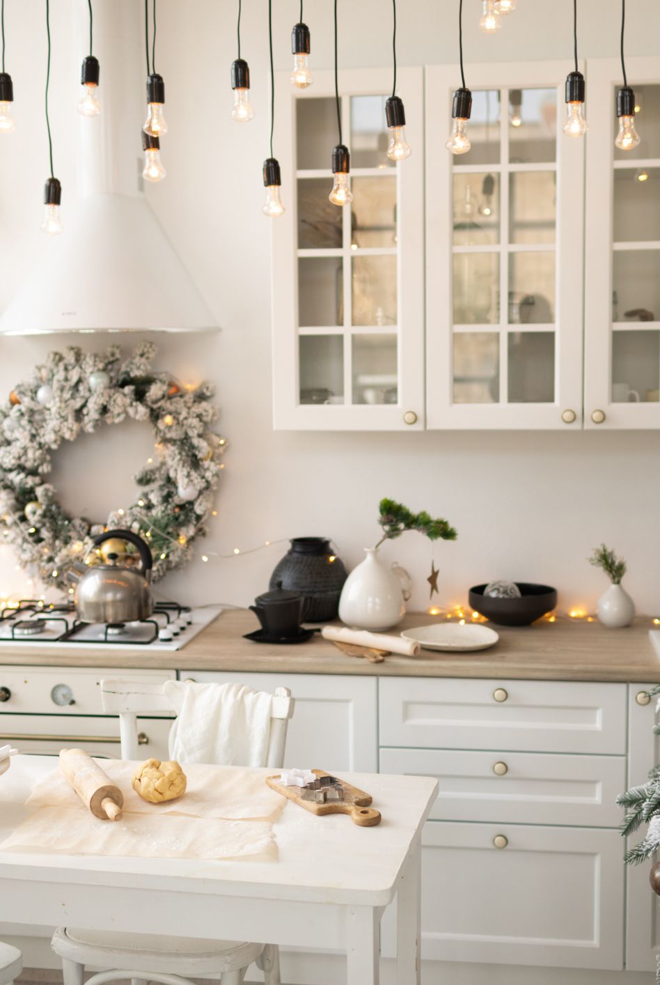interior white kitchen with christmas decor and decorated fir tree