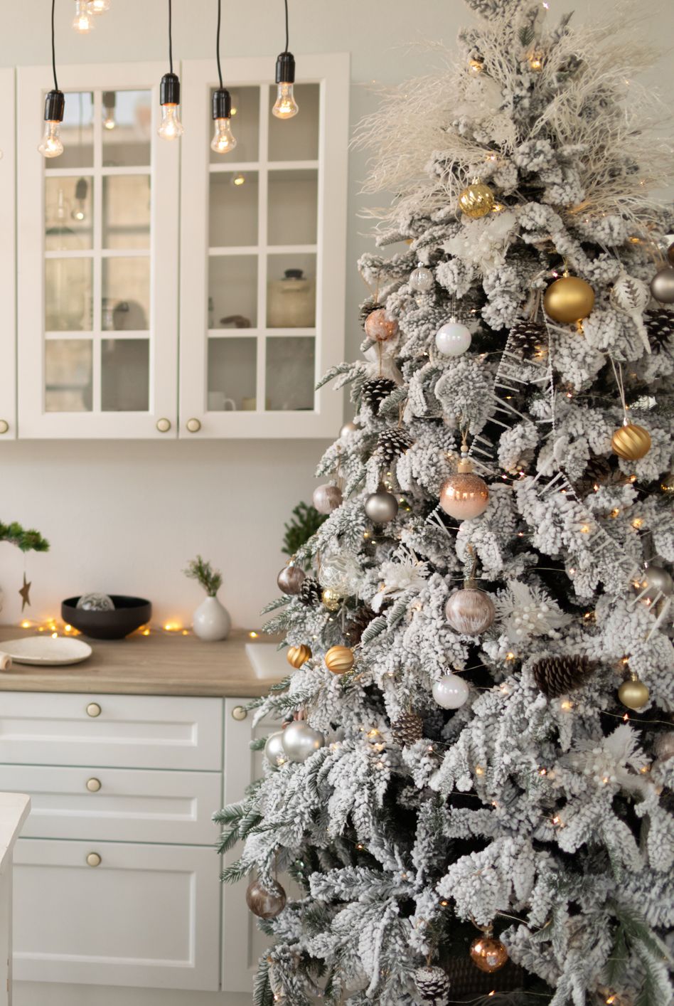 interior white kitchen with christmas decor and decorated fir tree