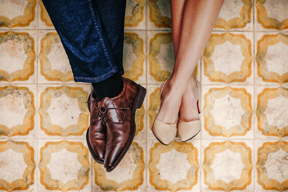 top view of feet in formal shoes at nice, outdoor tiles.