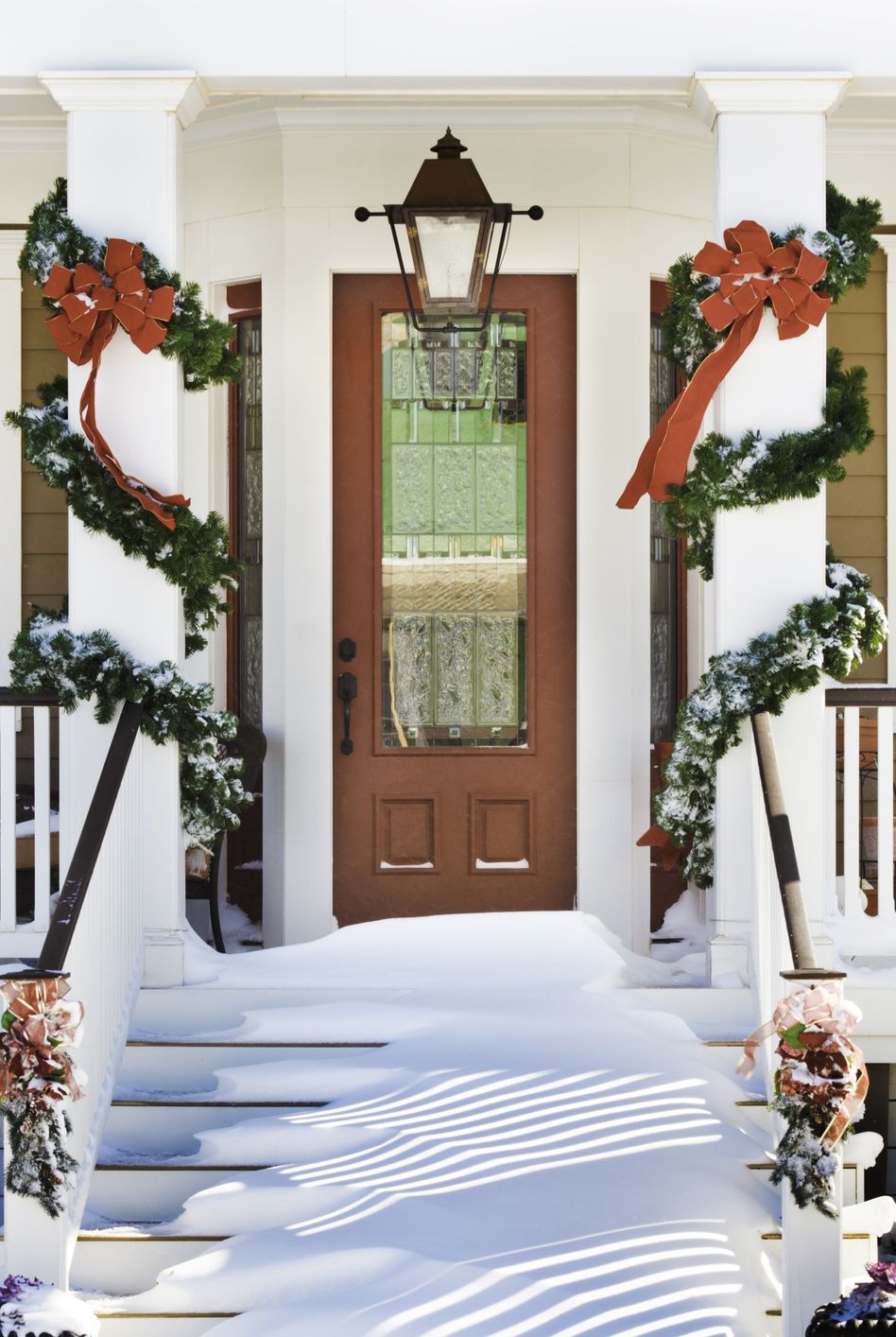 inviting christmas front doorway with snow on porch stairs