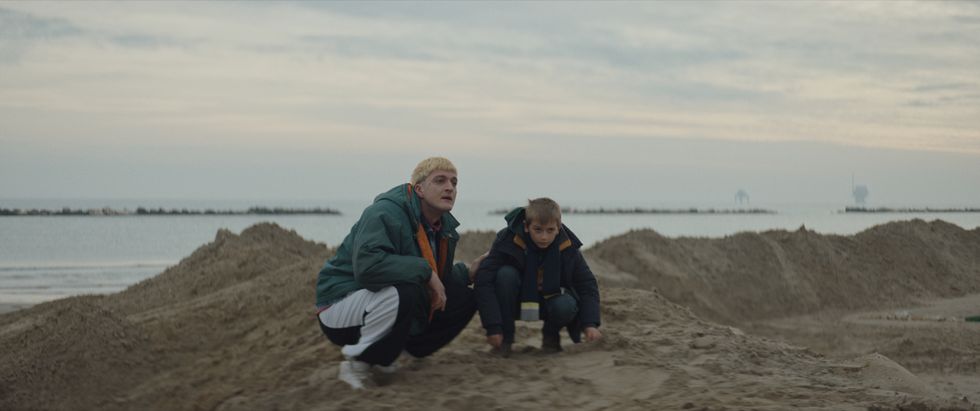 a man and a boy sitting on a beach