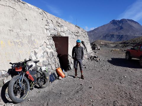 iohan gueorguiev near a cave with his bike nearby