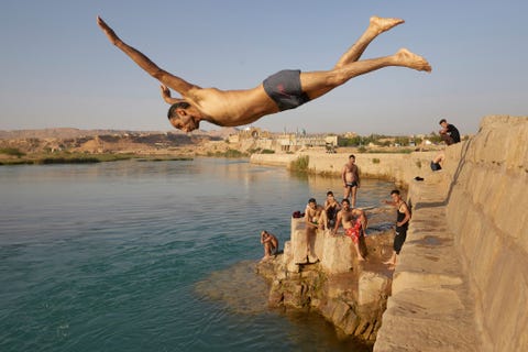 In de Iraanse stad Shushtar neemt een man een duik in de rivier de Karoen Het oude en vernuftige irrigatiestelsel van de stad werd in 2009 als Werelderfgoed erkend