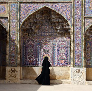 a n iranian woman dressing chador in the courtyard of the pink mosque in shiraz, iran