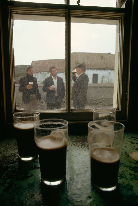 Veehandelaren drinken bier buiten bij de enige pub op Inishmaan een van de Aran eilanden in Galway Bay voor de westkust van Ierland De foto stond in een artikel van National Geographic uit 1971