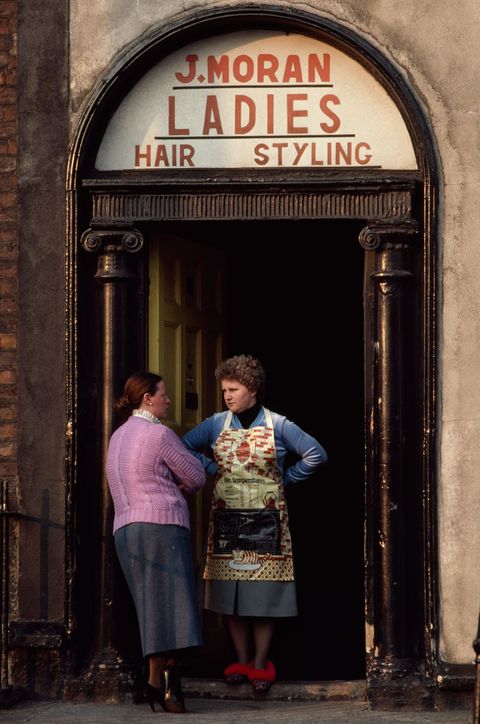 Vrouwen roddelen bij de ingang van een winkel in de Summerhill wijk van Dublin Toen de foto in een artikel van National Geographic uit 1981 stond was de hele wijk op het punt verbouwd te worden