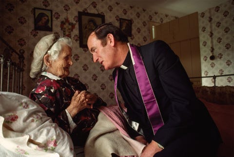 Een katholieke priester legt zijn maandelijkse bezoekje af aan een 90jarige bedlegerige vrouw in Templemore in een foto uit 1981 van National Geographic