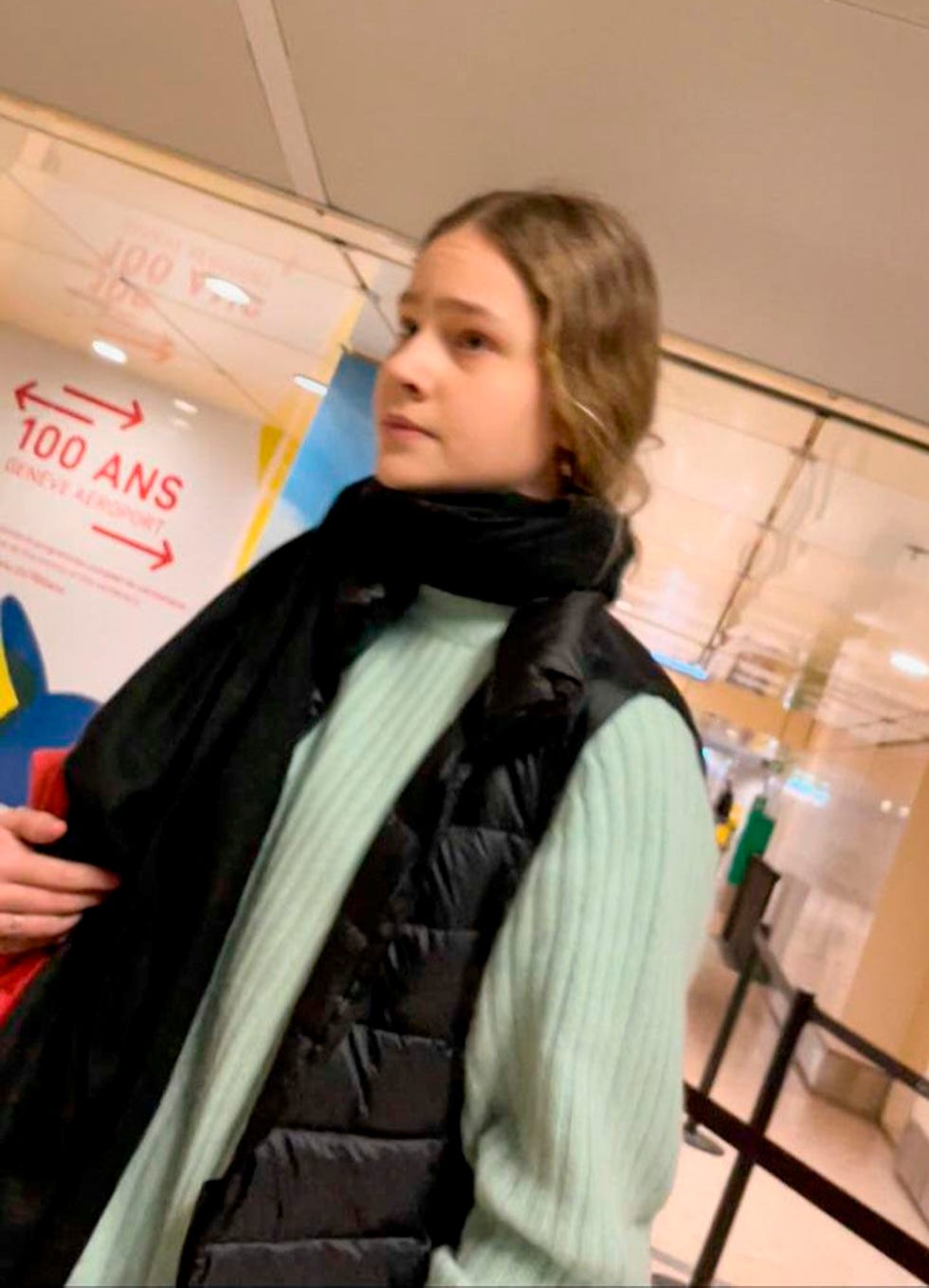 la hija pequeña de la infanta cristina e iñaki urdangarin con un jersey verde en el aeropuerto de suiza