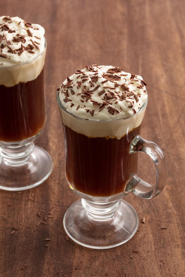 a cup of irish coffee with chocolate shavings on top