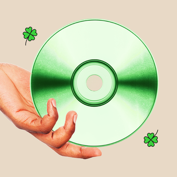 an arm and hand holding a cd that is tinted green