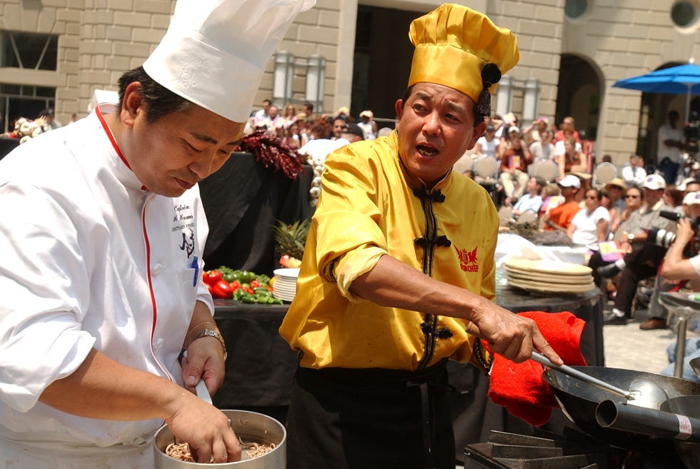 iron chef, kenichi chin, right, prepares a dish at a competi
