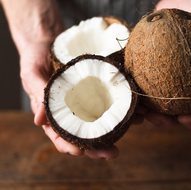 coconuts holding in hands unrecognizable man or woman propose to taste delicious tropical nut