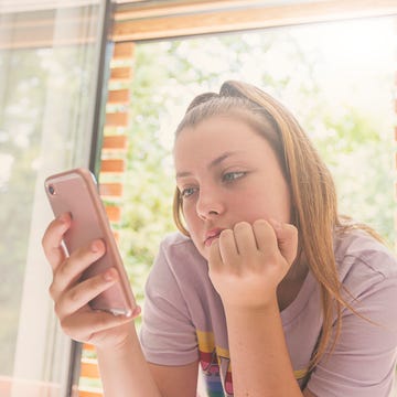 Teenage Girl using smartphone in bedroom teenage girl using smartphone in bedroom