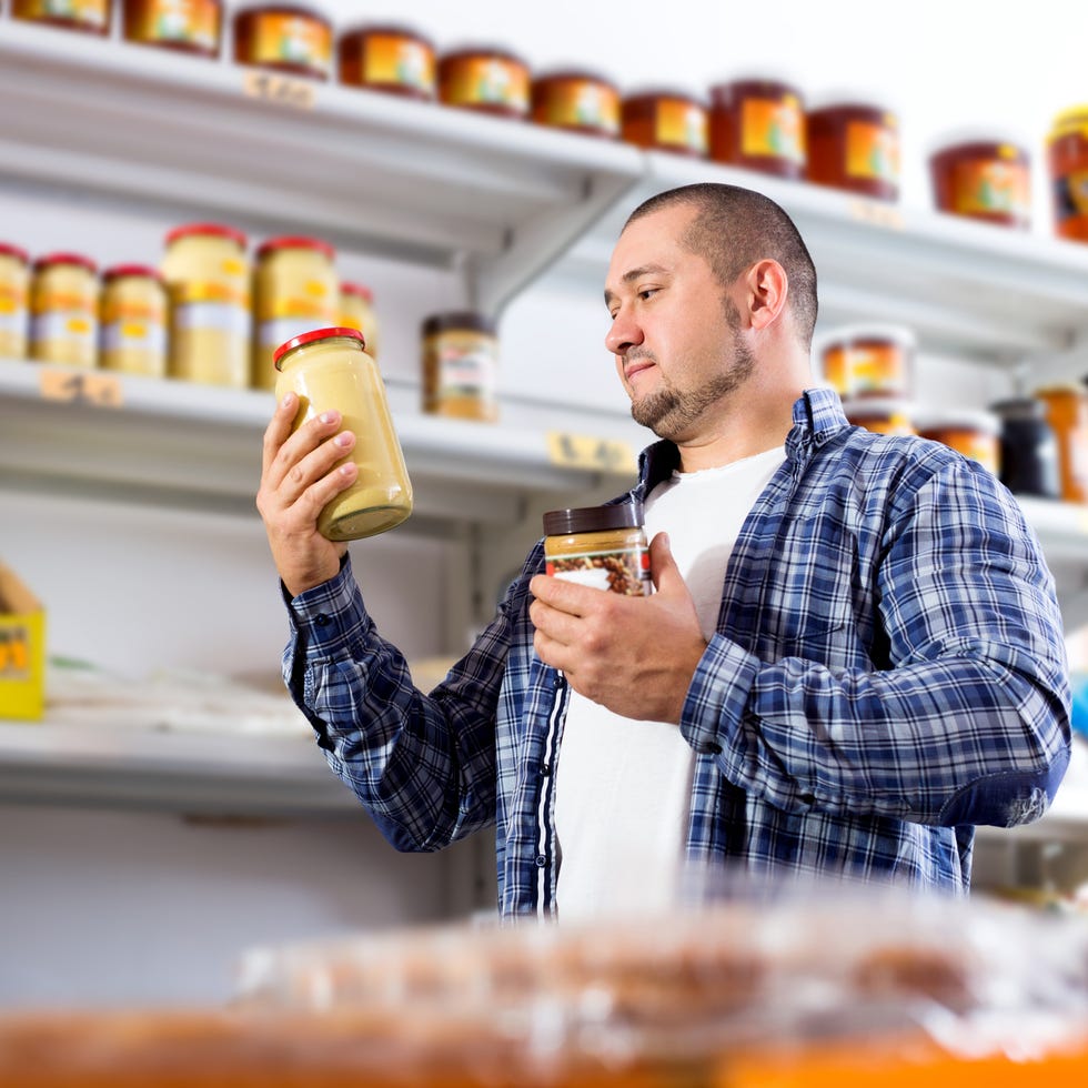 portrait of ordinary man purchasing peanut butter in grocery