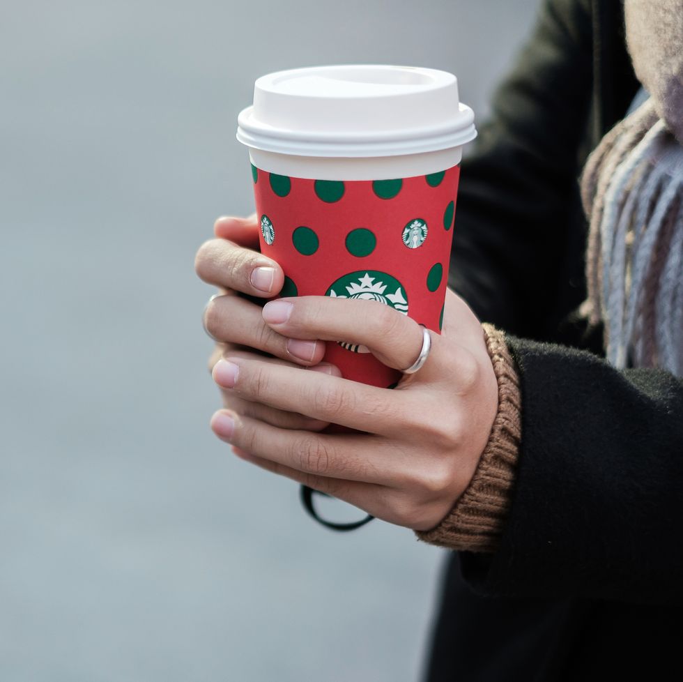 woman hands holding hot starbucks coffee paper cup, for christmas and happy new year collection kunming, china, december 10, 2019