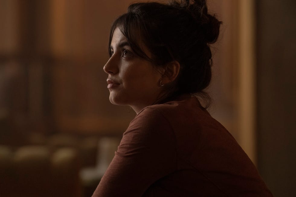 Isabela Merced seduta in uno spazio interno scarsamente illuminato nella seconda stagione di The Last of Us