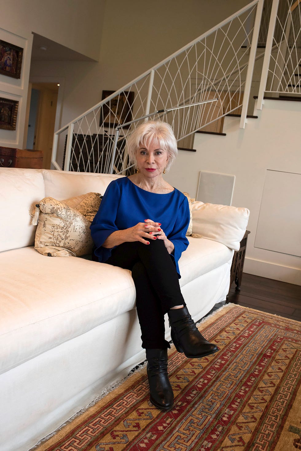 la escritora, de 79 años, sentada en el salón de su casa