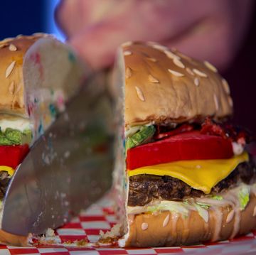 hyperrealistic cake meant to look like a cheeseburger being cut in half with a knife